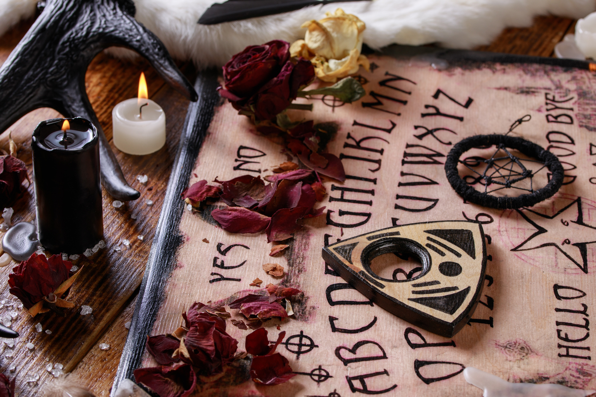 Spiritual board ouija with candles close-up. Mystical ritual of calling dead spirits. Macro.